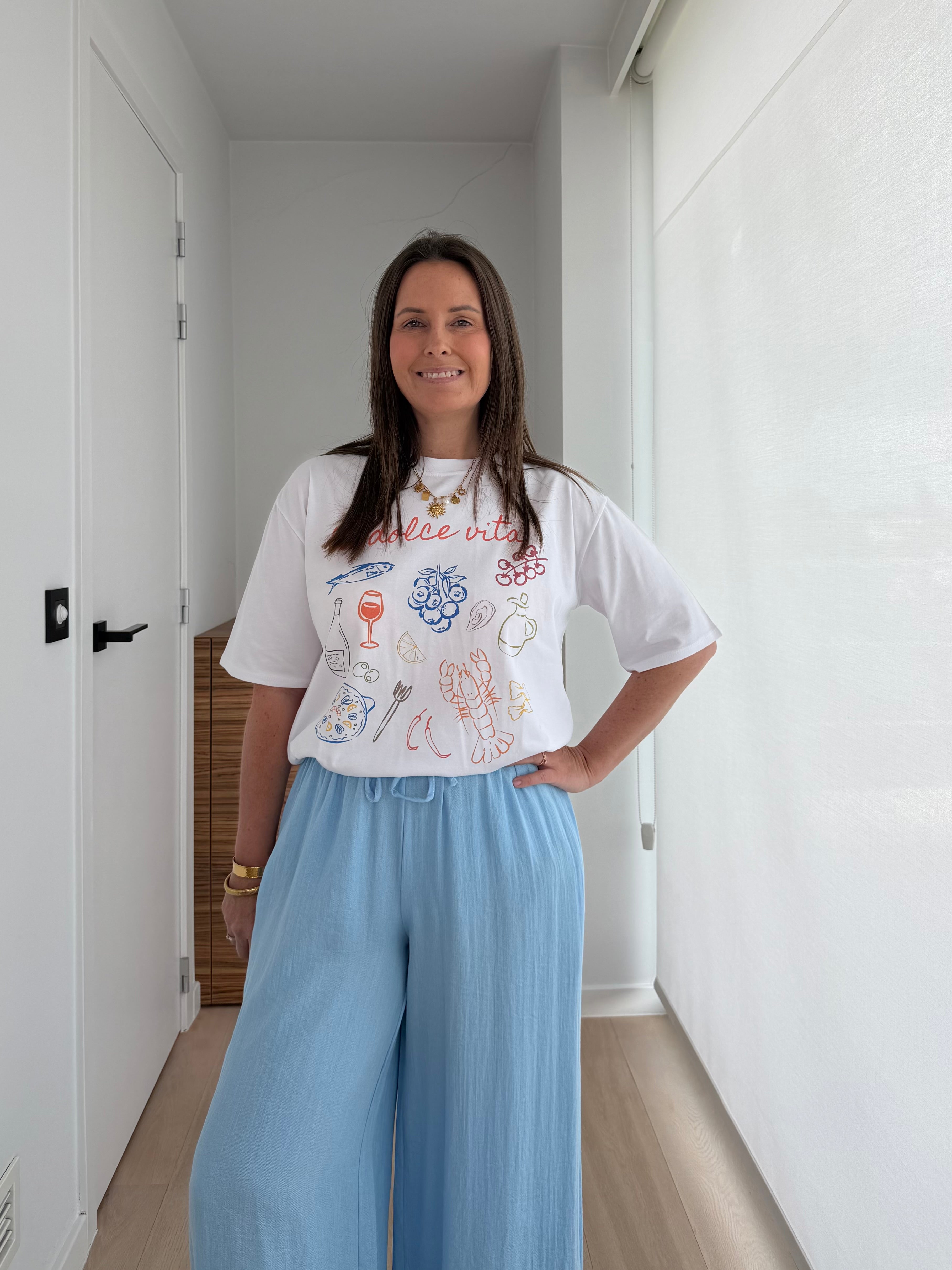 Oversized witte dames T-shirt gecombineerd met lichtblauwe wide leg broek