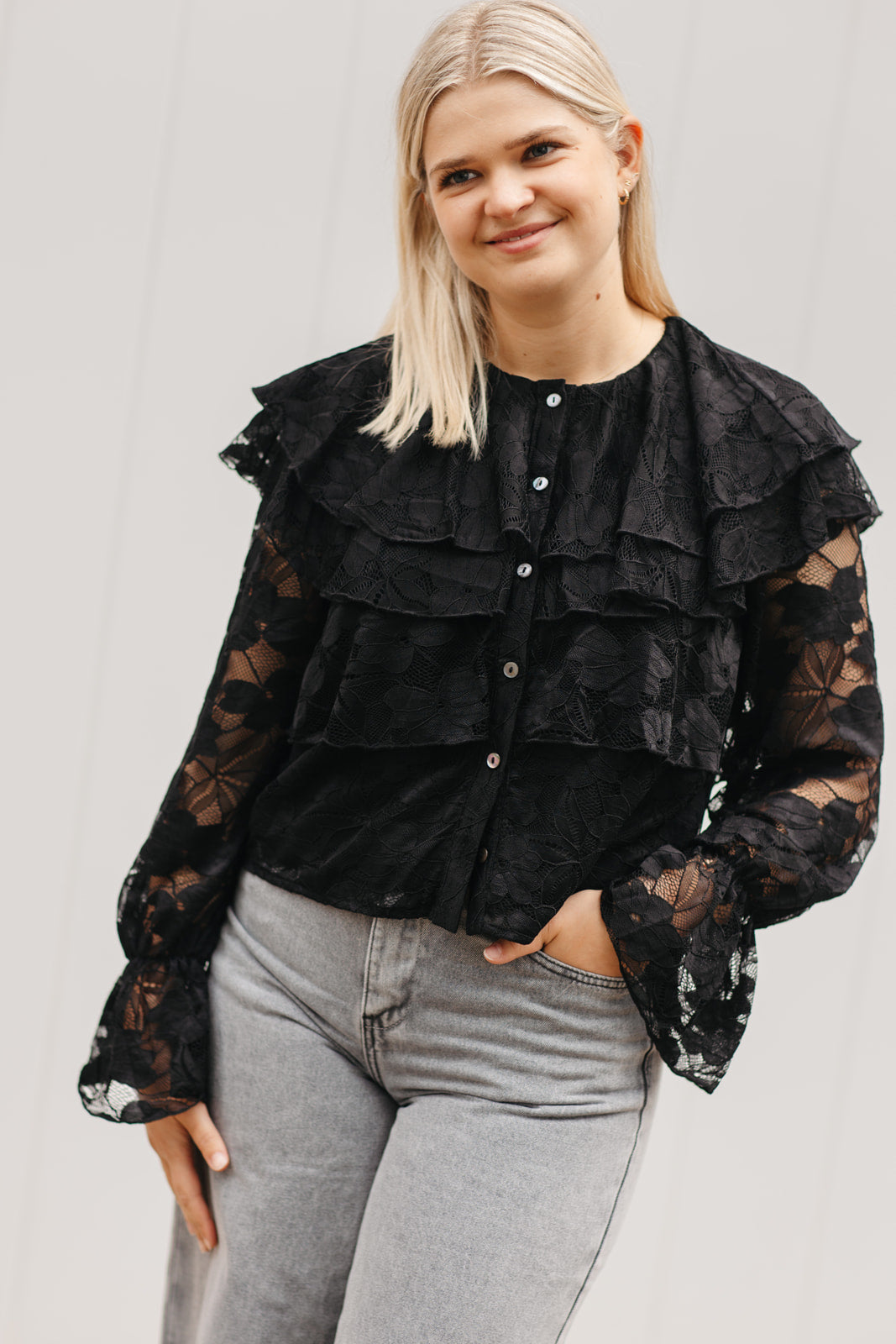 Zwarte blouse met bloemenstructuur – luxueuze dames blouse met volant mouwen en knopen vooraan