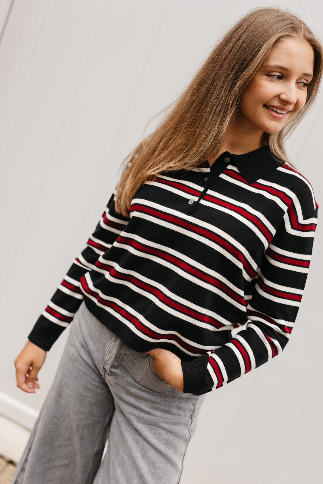 Gestreepte polo dames – zwarte top met polokraag, lange mouwen en elegante afwerking