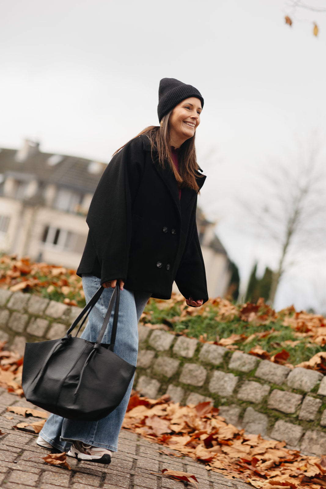 Outfit met zwarte jas en rok – zijaanzicht