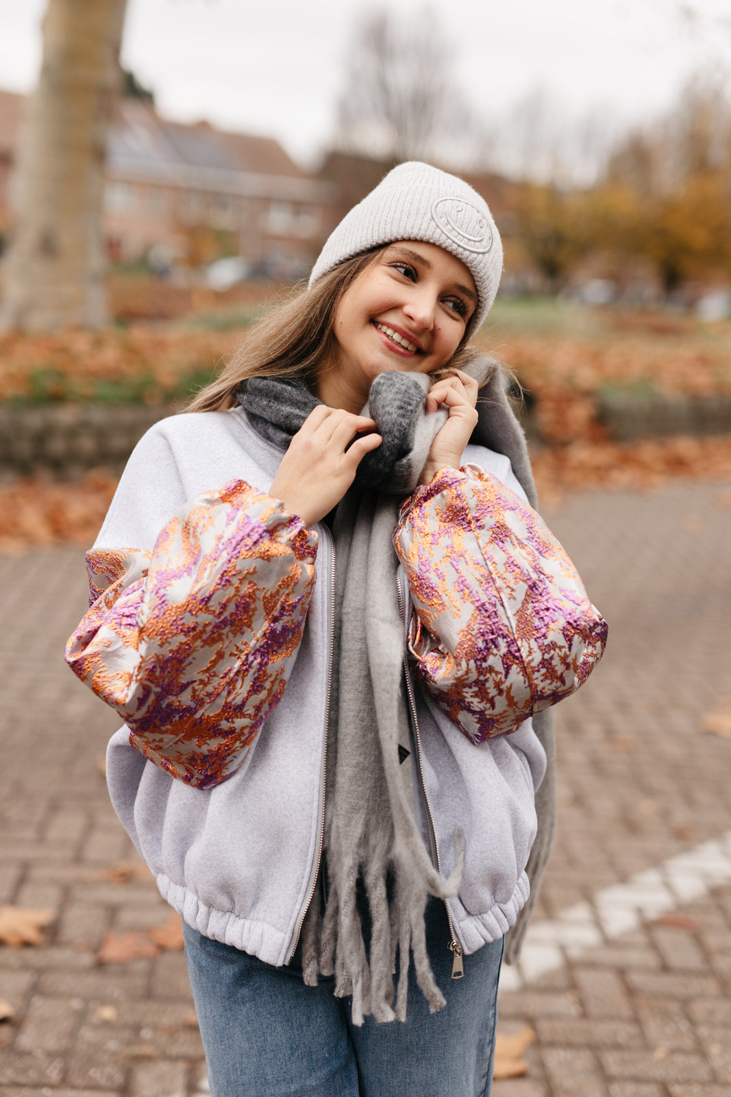 Grijze sweatervest met glanzende kleurrijke mouwen