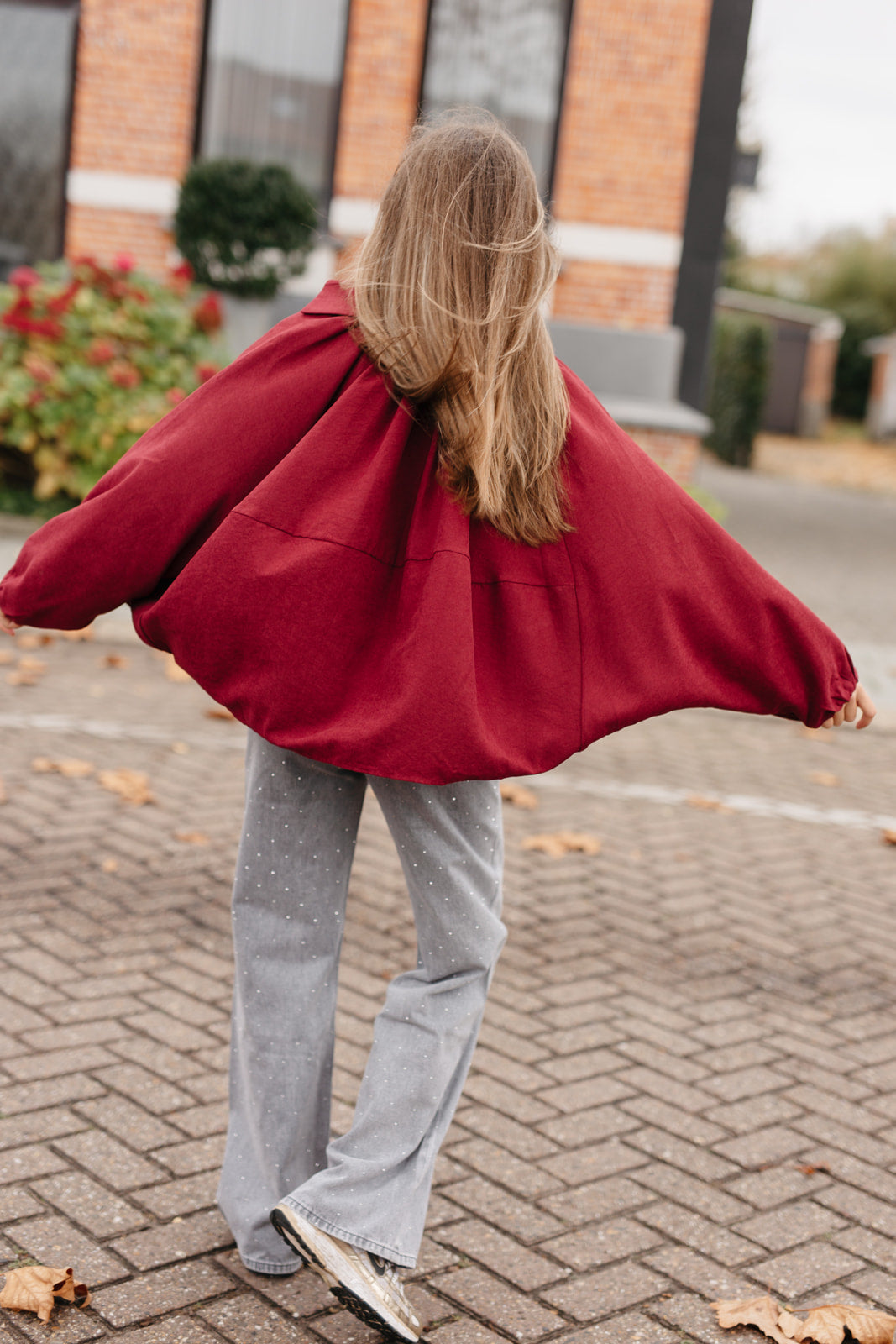 burgundy cropped jasje en vlindermouwen over een witte longsleeve