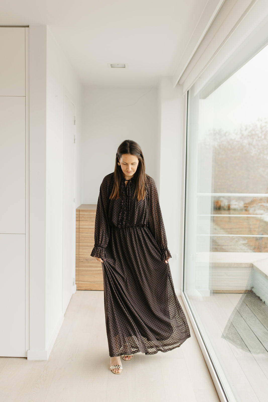 lang bruin kleedje met bolletjes en sierstrik aan de hals