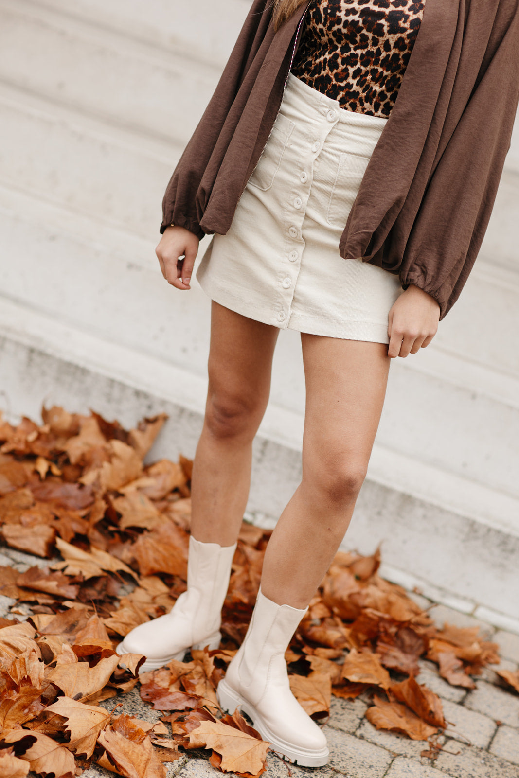 Beige kort rokje met knopen en zakken – vooraanzicht