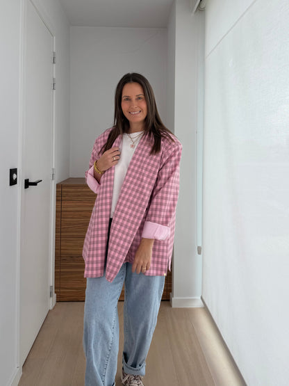 Statement blazer in roze ruitjesprint gecombineerd met jeans en sneakers