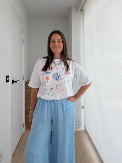 Oversized witte dames T-shirt gecombineerd met lichtblauwe wide leg broek