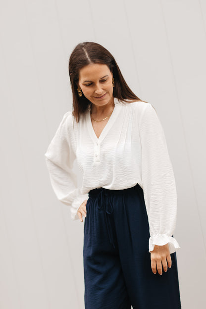 Elegante beige top – blouse met opstaande kraag, fijne knoopjes en vrouwelijke pasvorm