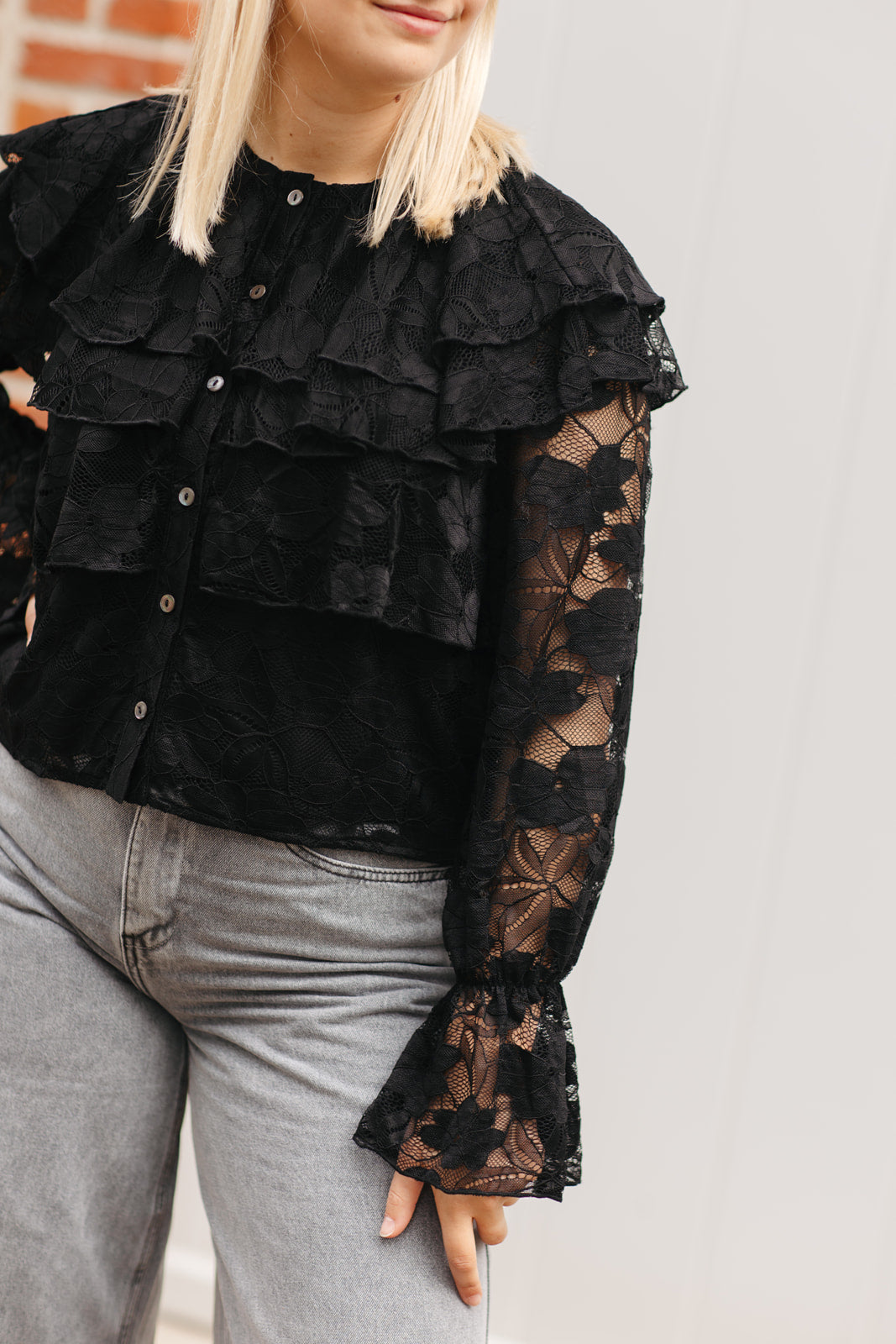 Elegante zwarte blouse – dames top met subtiele glans en ruffle details aan de schouders