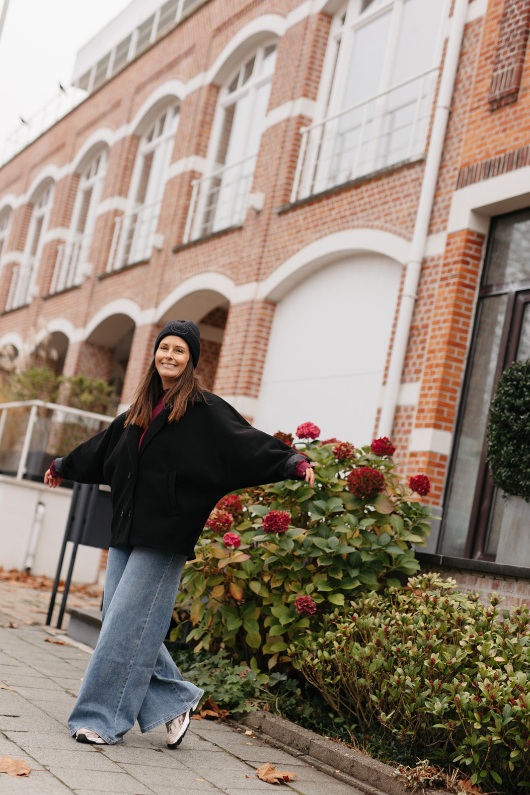 Outfit met zwarte jas en rok – zijaanzicht