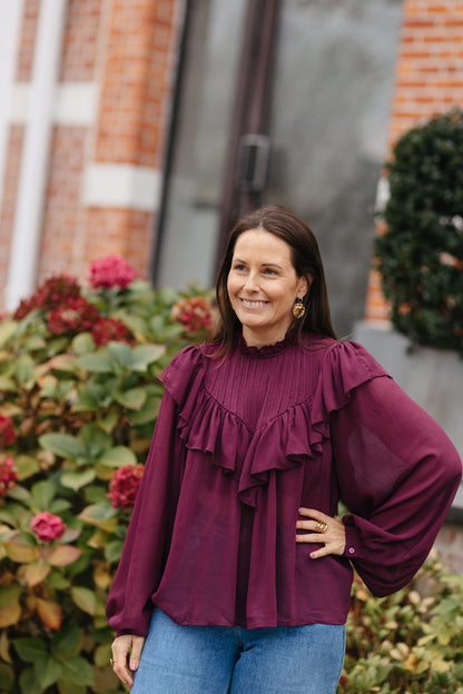 transparante burgundy blouse met opstaande kraag en jeans