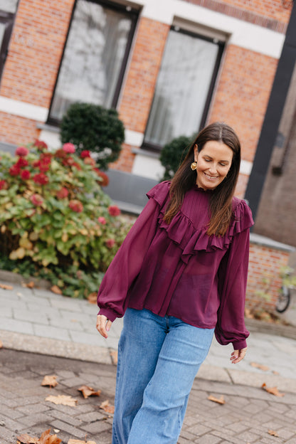 transparante burgundy blouse met opstaande kraag en jeans
