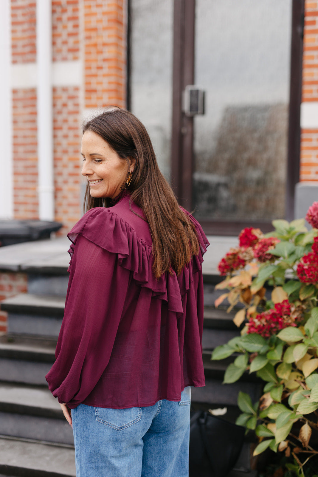 transparante burgundy blouse met opstaande kraag en jeans