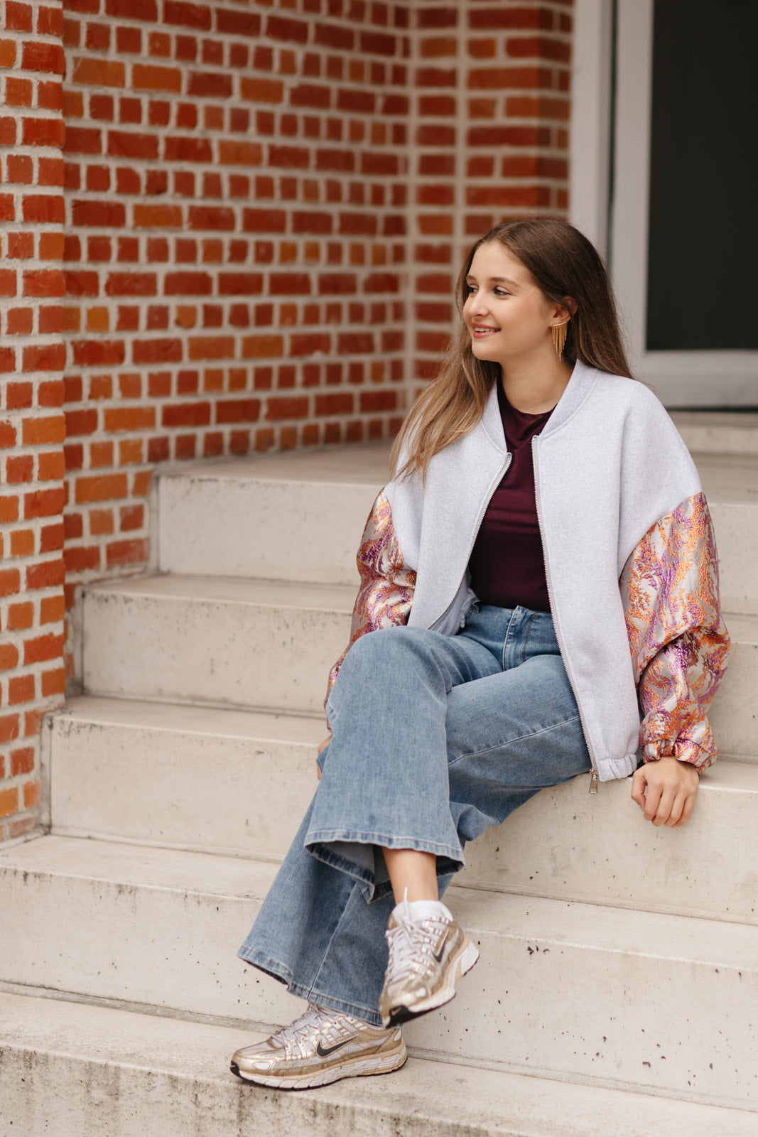 Grijze sweatervest met glanzende kleurrijke mouwen