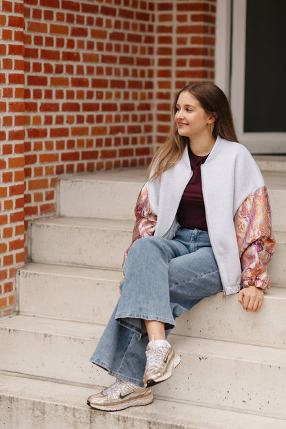 Grijze sweatervest met glanzende kleurrijke mouwen