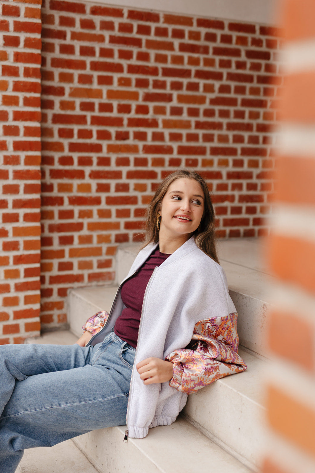 Grijze sweatervest met glanzende kleurrijke mouwen