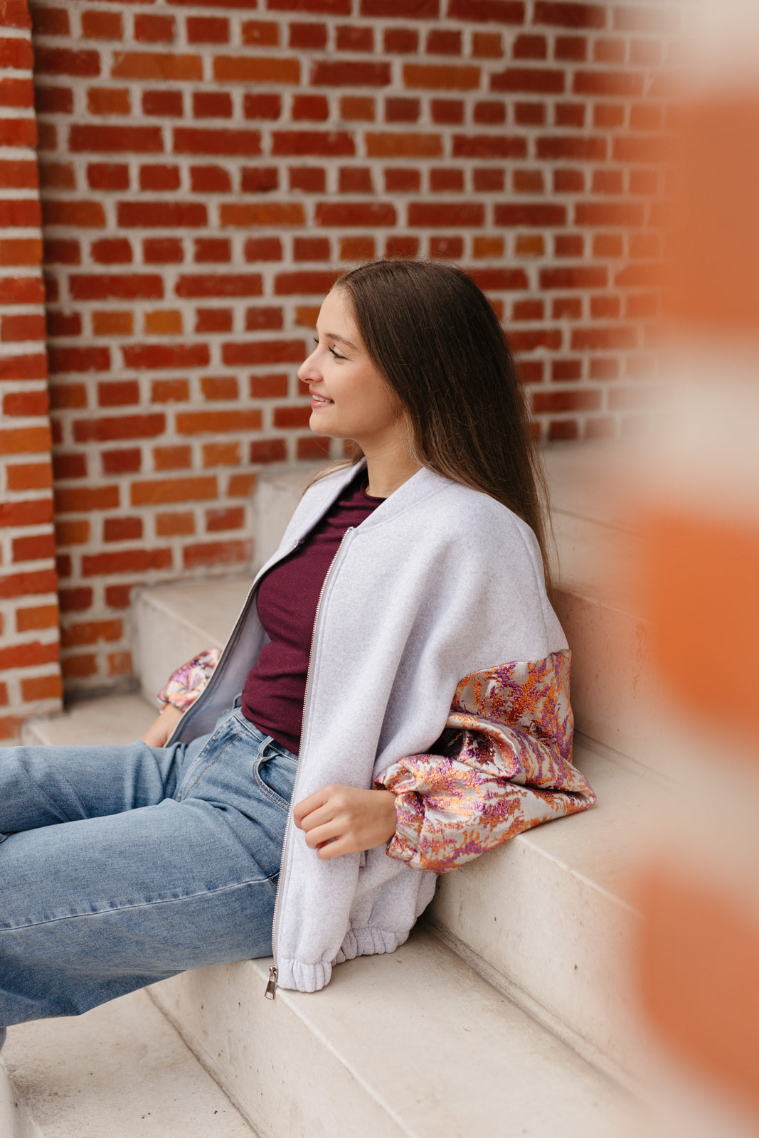 Grijze sweatervest met glanzende kleurrijke mouwen