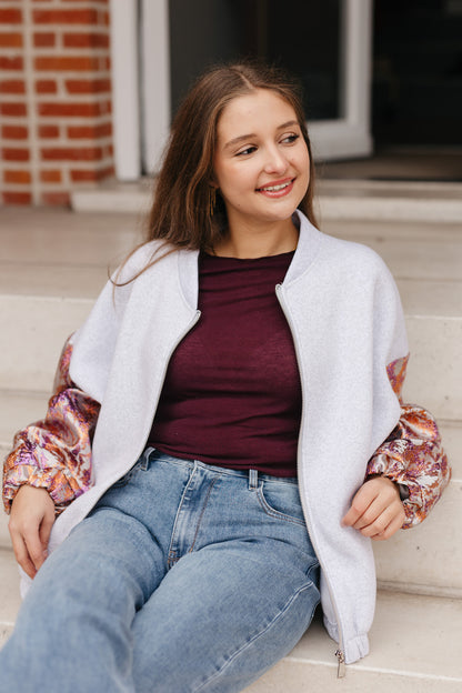 Grijze sweatervest met glanzende kleurrijke mouwen