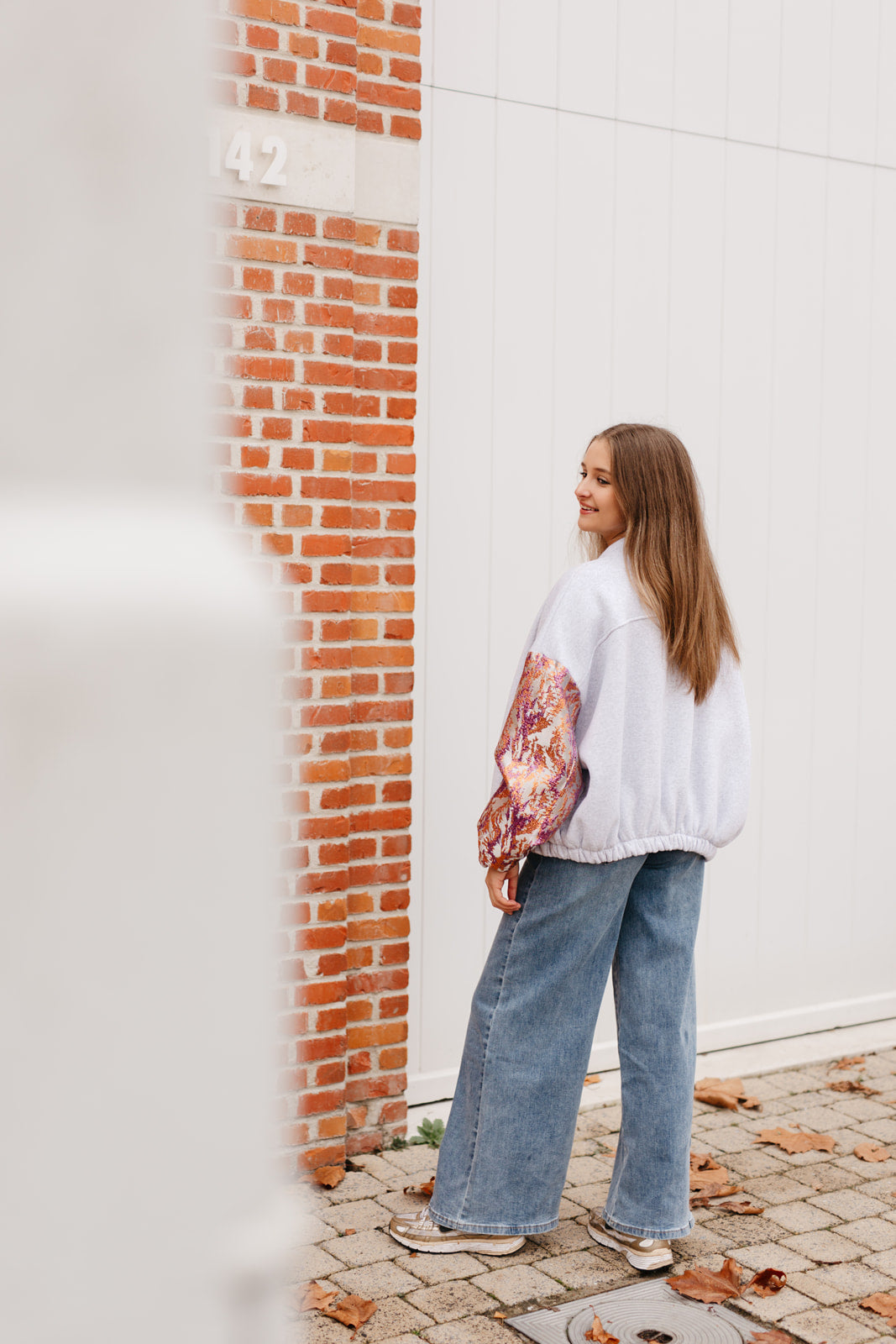 Grijze sweatervest met glanzende kleurrijke mouwen