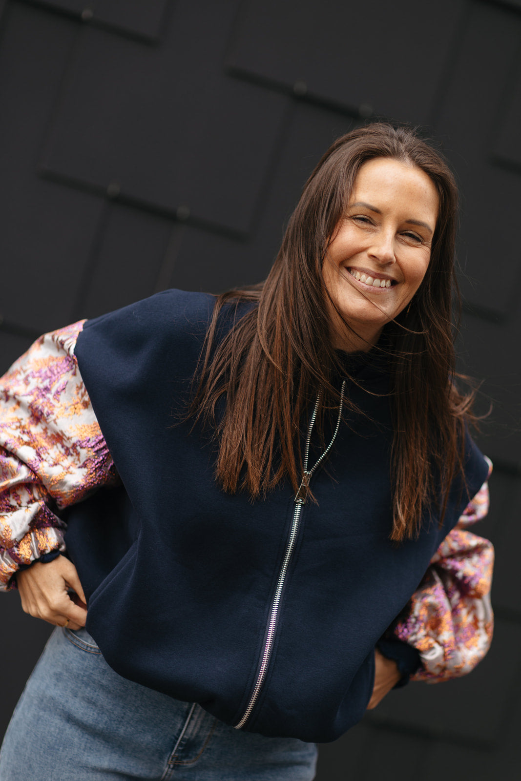 Marineblaue sweatervest met glanzende kleurrijke mouwen