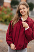 burgundy cropped jasje en vlindermouwen over een witte longsleeve