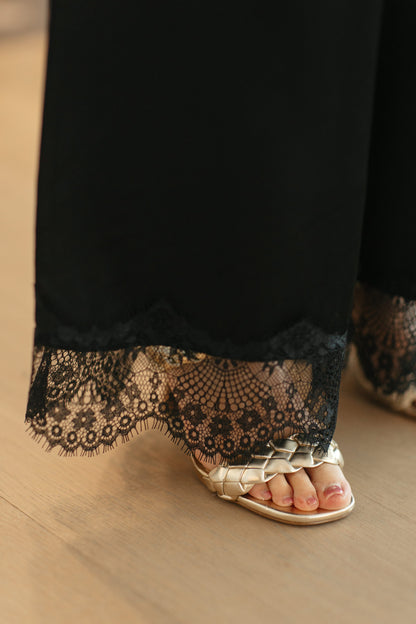 Model draagt feestelijke set met wijde broek en kanten top zonder mouwen