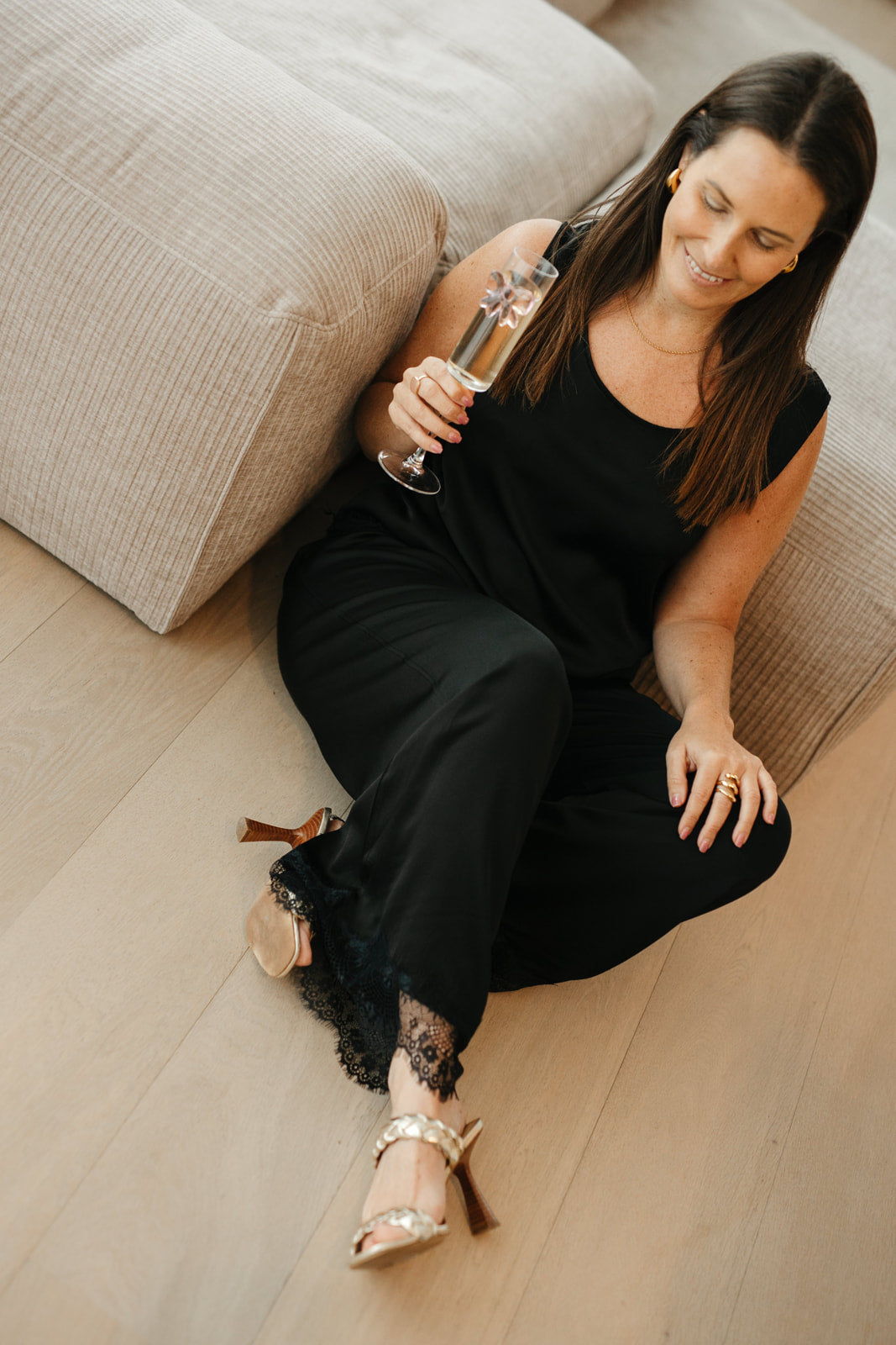 Model draagt feestelijke set met wijde broek en kanten top zonder mouwen