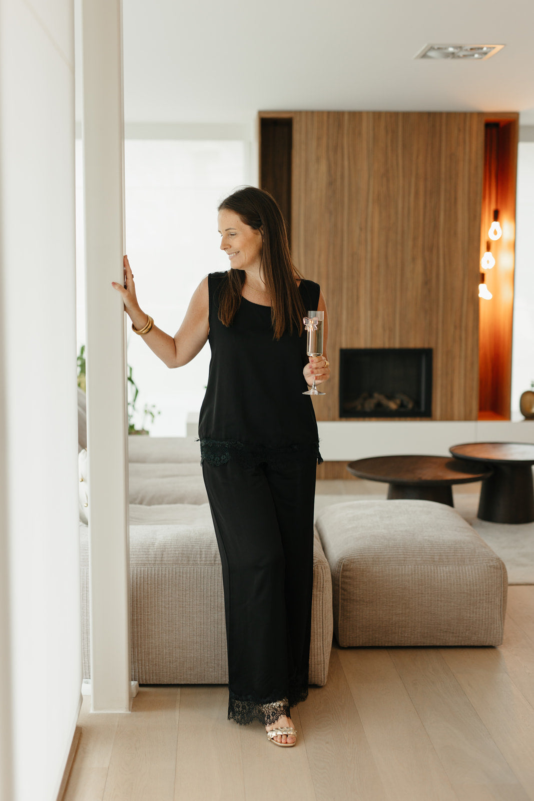 Model draagt feestelijke set met wijde broek en kanten top zonder mouwen