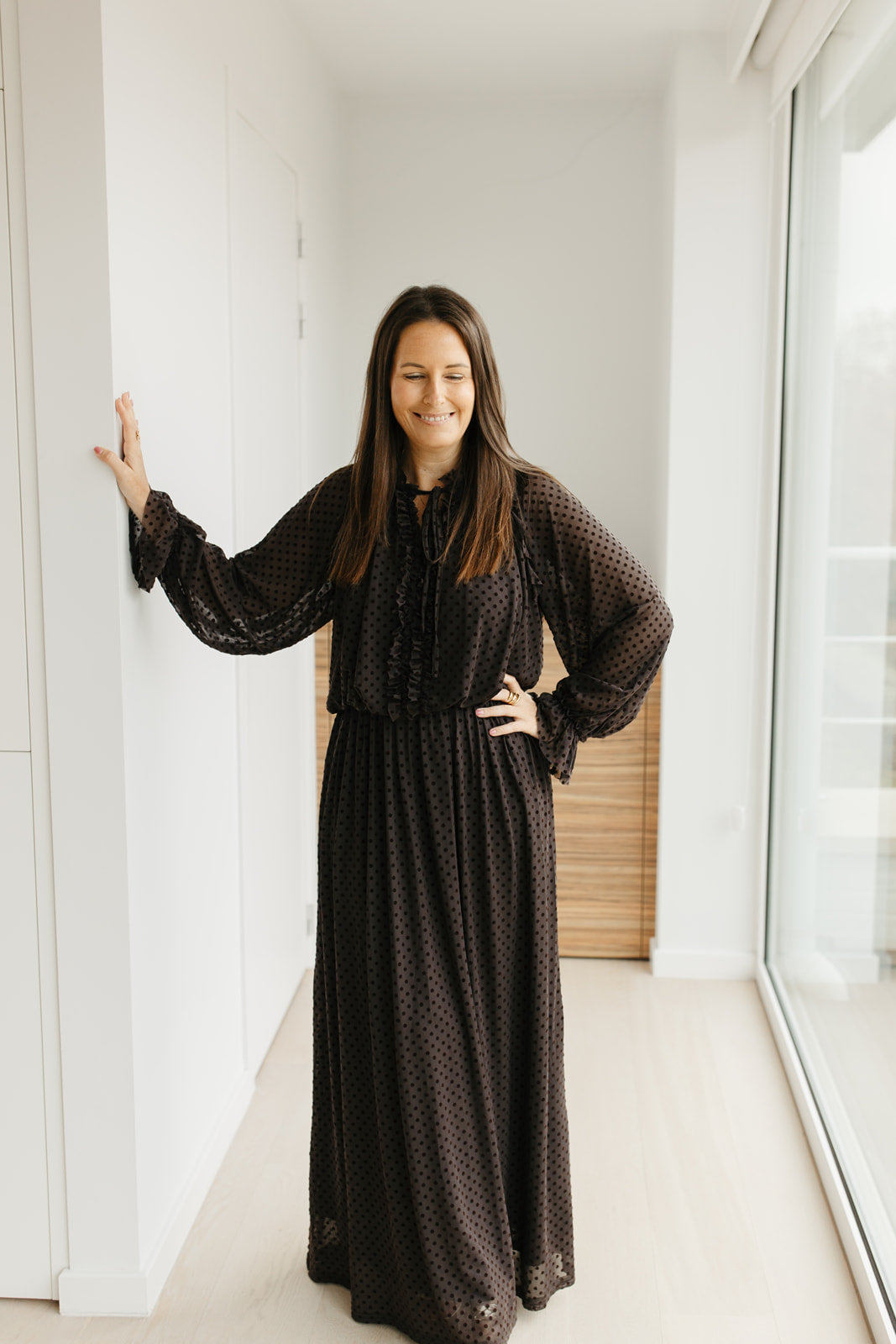 lang bruin kleedje met bolletjes en sierstrik aan de hals