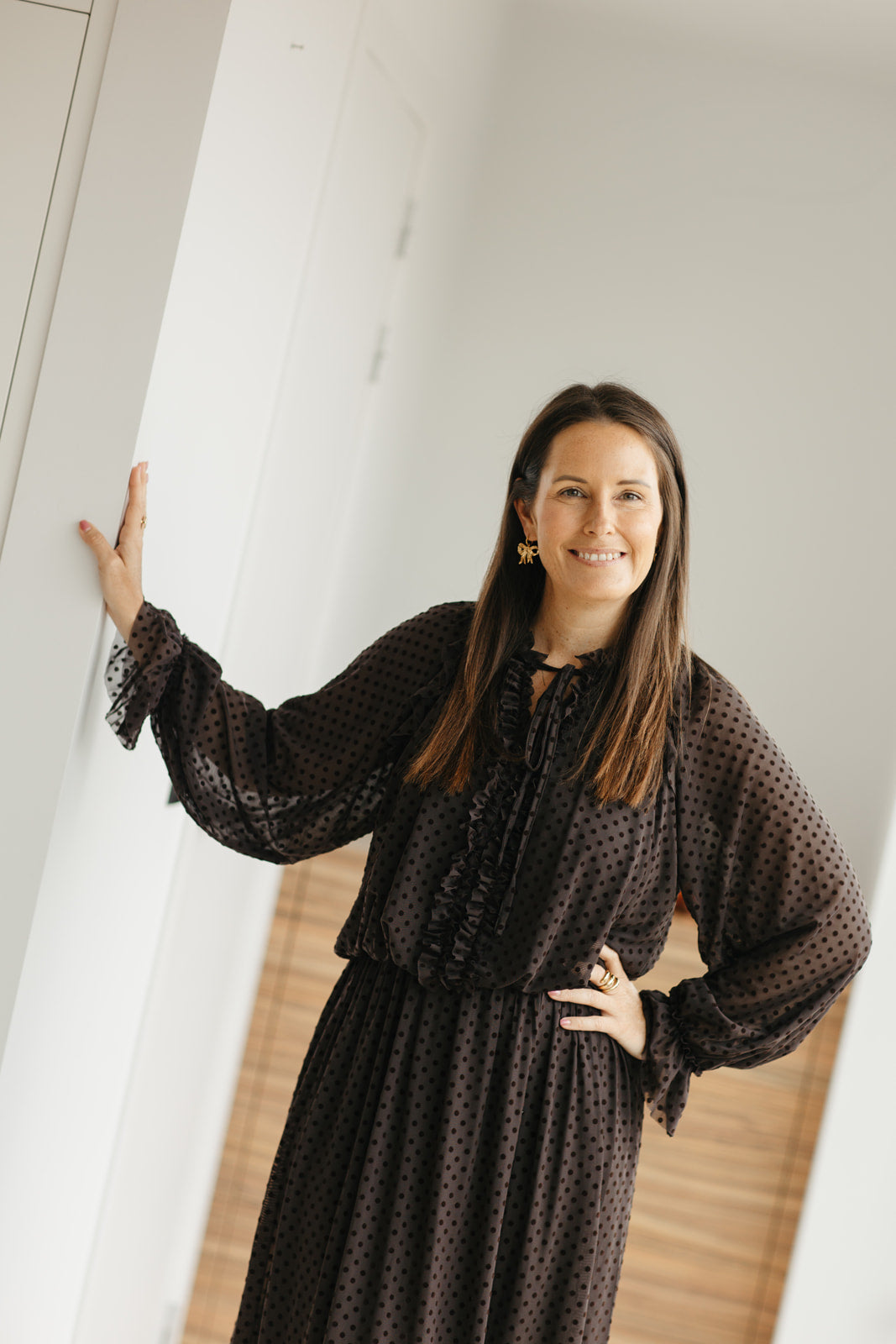 lang bruin kleedje met bolletjes en sierstrik aan de hals