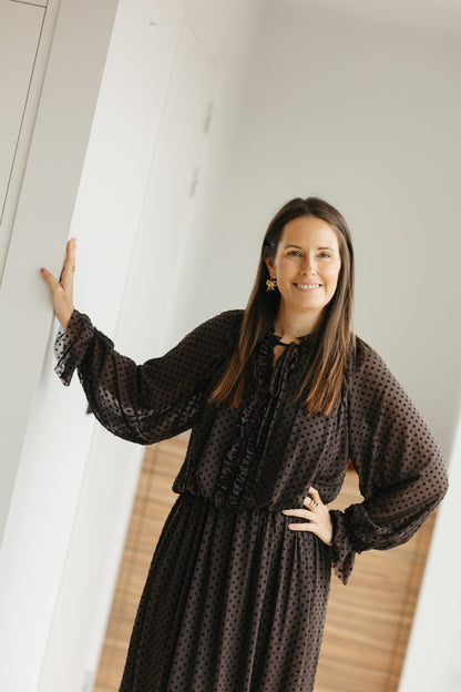 lang bruin kleedje met bolletjes en sierstrik aan de hals