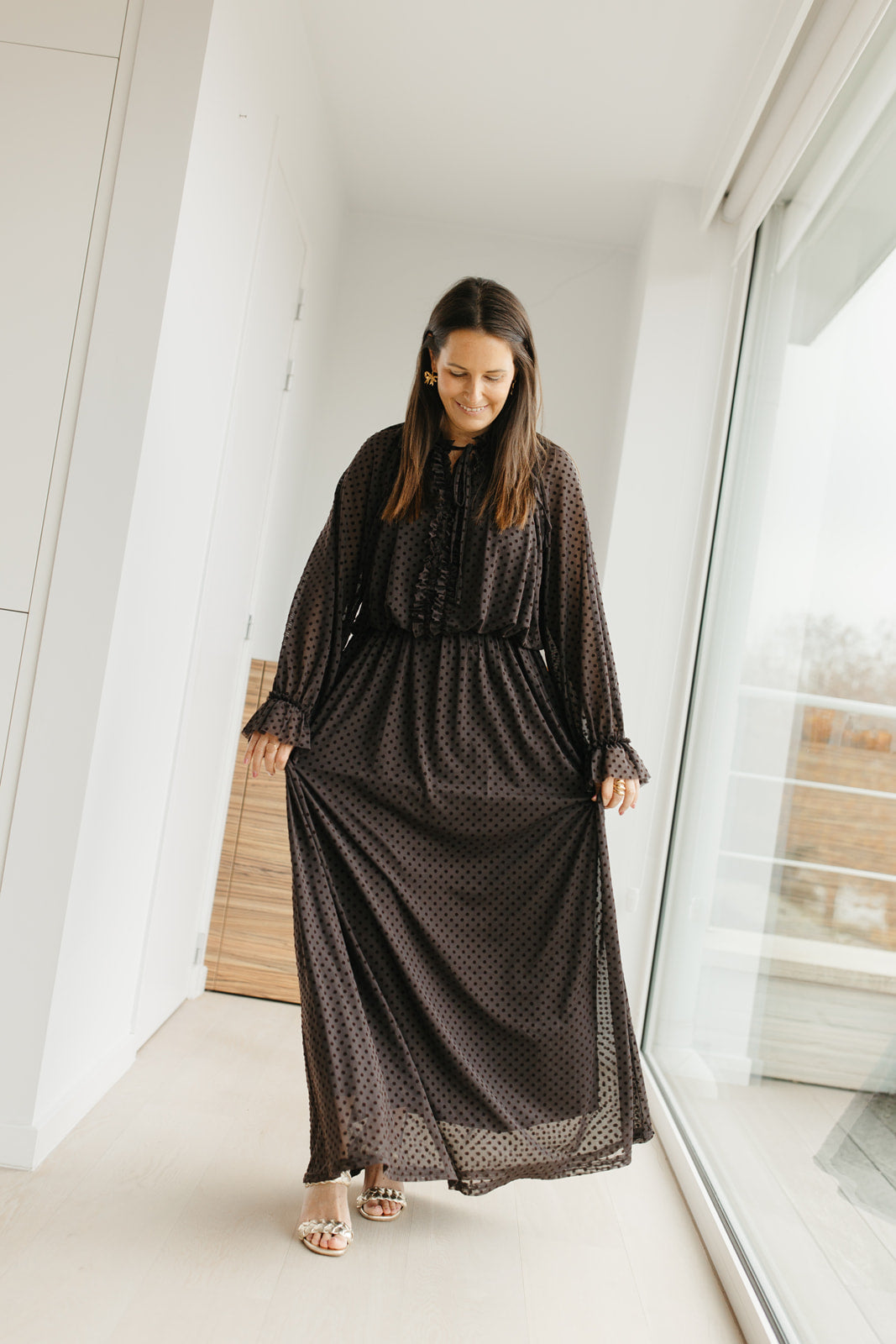 lang bruin kleedje met bolletjes en sierstrik aan de hals