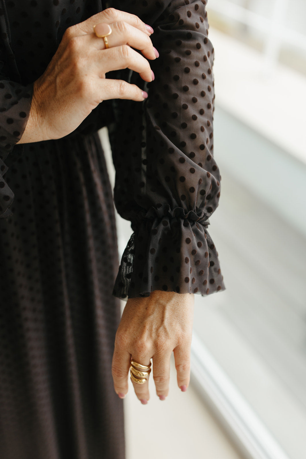 lang bruin kleedje met bolletjes en sierstrik aan de hals