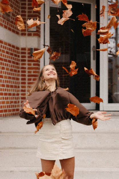 Beige kort rokje met knopen en zakken – vooraanzicht